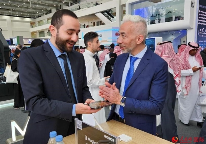 兩名觀眾在榮耀手機(jī)展臺前交流。人民網(wǎng)記者 管克江攝