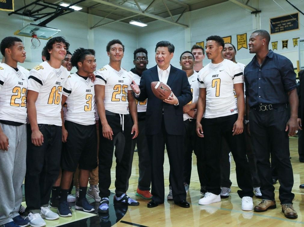 2015年9月23日，國(guó)家主席習(xí)近平參觀美國(guó)塔科馬市林肯中學(xué)。這是習(xí)近平在學(xué)校體育館，同上橄欖球訓(xùn)練課的學(xué)生們親切交談。新華社記者 蘭紅光 攝