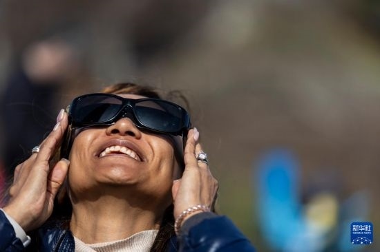 4月8日，一名女子在美國(guó)紐約州普拉茨堡觀看日食。新華社發(fā)（文森特·約翰遜攝）