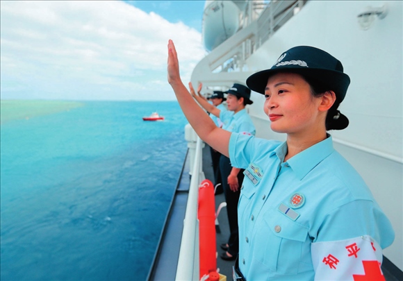 中國海軍“和平方舟”號醫(yī)院船結(jié)束訪問湯加時，任務(wù)官兵中的文職人員向歡送人群揮手告別（2023年8月4日攝）。徐巍攝/本刊