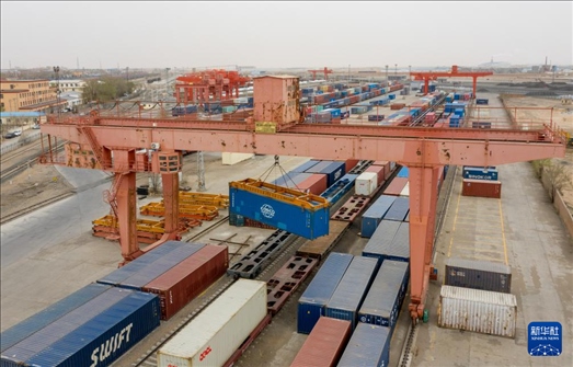 4月21日，二連浩特鐵路口岸龍門吊吊裝中歐班列集裝箱（無人機照片）。 新華社發(fā)（張海峰攝）