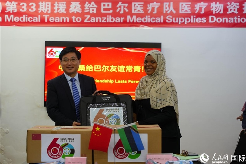 江蘇省蘇北人民醫(yī)院黨委書記束余聲捐贈物資與桑衛(wèi)生部首席秘書哈比巴。中國援桑醫(yī)療隊供圖