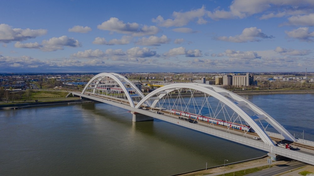 2024年3月12日，一列火車運(yùn)行在匈塞鐵路塞爾維亞境內(nèi)貝諾段諾維薩德多瑙河大橋上（無人機(jī)照片）。新華社發(fā)（任衛(wèi)云攝）