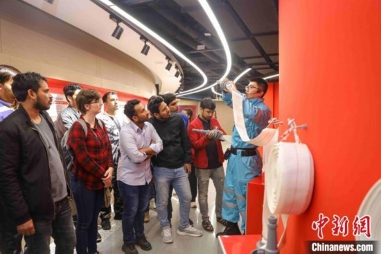 5月9日，工作人員指導(dǎo)留學(xué)生正確使用消防水帶。張鷹 攝