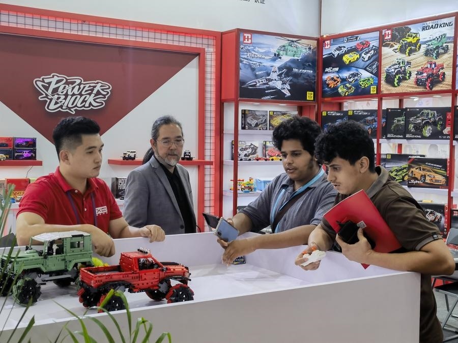 在第135屆廣交會(huì)第三期現(xiàn)場(chǎng)，采購(gòu)商在廣東信宇科技股份有限公司展位選購(gòu)、體驗(yàn)積木遙控車產(chǎn)品（5月2日攝）。新華社記者 洪澤華 攝