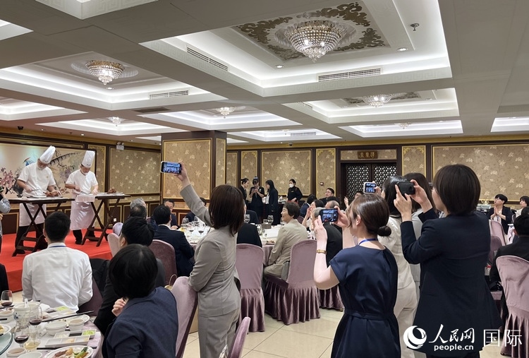 國家級非物質(zhì)文化遺產(chǎn)、全聚德片鴨工藝吸引代表團成員拍照留念。