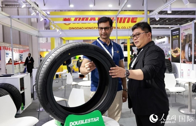工作人員向客戶展示雙星電動(dòng)汽車輪胎。和傳統(tǒng)汽車輪胎相比，電動(dòng)汽車輪胎具有更高承載能力、更加靜音舒適、更好極速抓地、更低滾動(dòng)阻力等特點(diǎn)。人民網(wǎng)記者 管克江攝