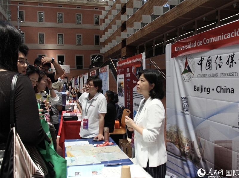 旅西華人華僑在展臺前咨詢。人民網記者 許海林攝