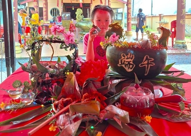 小朋友展示學裹粽子的成品照。組委會供圖