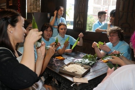 6月9日，美國青年代表在重慶永川松溉古鎮(zhèn)體驗包粽子。新華社記者 周思宇 攝