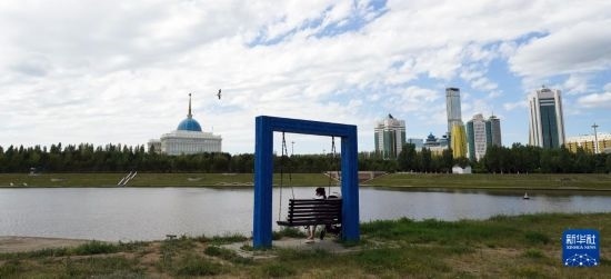 6月30日，一名女子在哈薩克斯坦首都阿斯塔納伊希姆河畔休息。新華社記者 王建華 攝