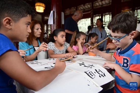 7月4日，在馬耳他桑塔露琪亞市的中國古典園林“靜園”，人們體驗中國書法。新華社發(fā)（喬納森·博格 攝）