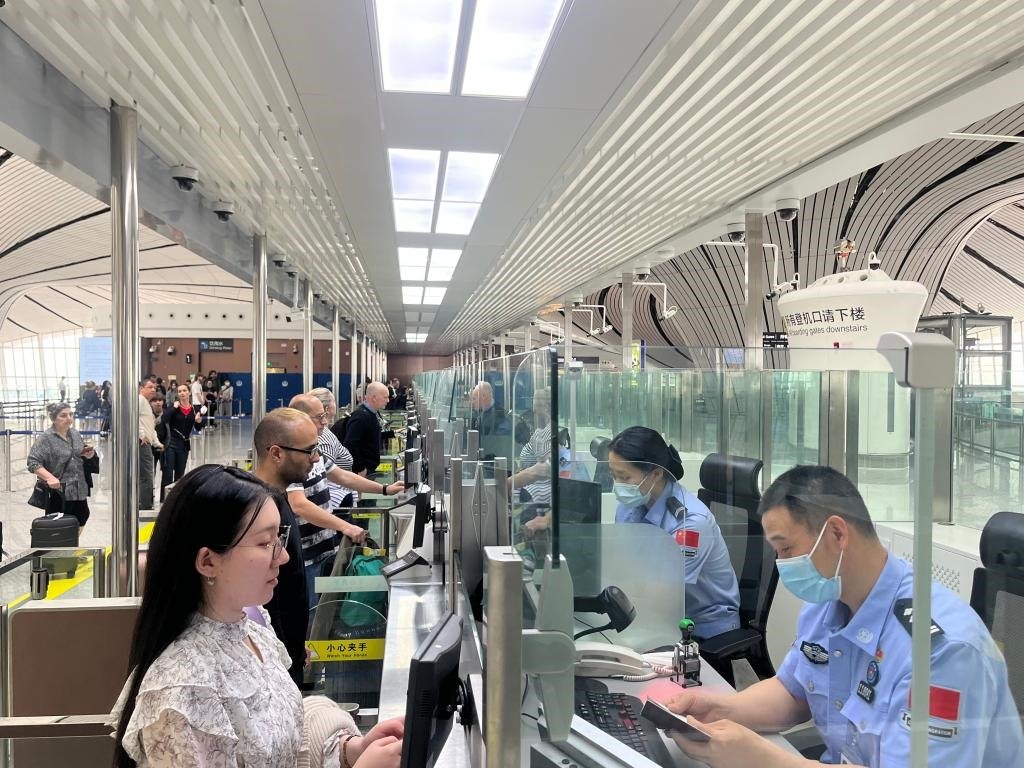 7月5日，北京大興國(guó)際機(jī)場(chǎng)邊檢站民警正在辦理邊檢查驗(yàn)手續(xù)。（北京大興國(guó)際機(jī)場(chǎng)邊檢站供圖）