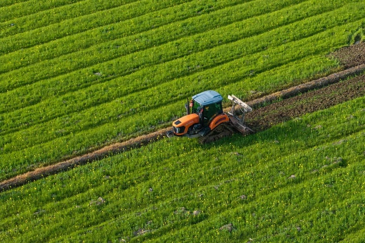 2024年3月19日，在湖南省常德市鼎城區(qū)謝家鋪鎮(zhèn)港中坪村，村民駕駛農(nóng)機(jī)翻耕田地（無人機(jī)照片）。新華社記者 陳思汗 攝