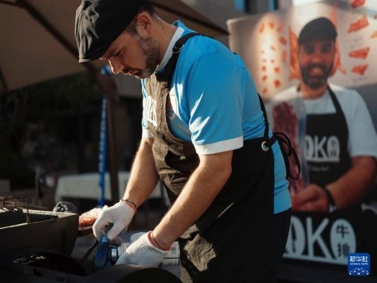 7月19日，在蕪湖古城，馬丁在當(dāng)天舉行的啤酒節(jié)上制作牛排。新華社發(fā)（繆雨晨 攝）