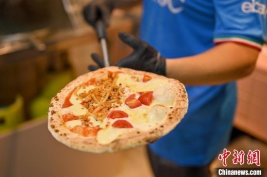 近日，韋榮耀展示他制作的“老友味”披薩。 俞靖 攝