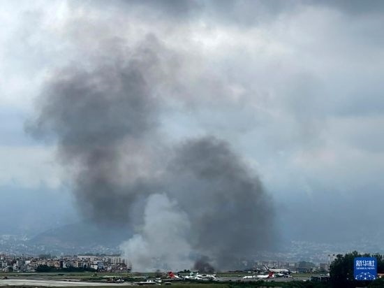 這是7月24日在尼泊爾加德滿都特里布萬機(jī)場拍攝的濃煙。目擊者說，一架飛機(jī)在尼泊爾加德滿都特里布萬機(jī)場墜毀。新華社/美聯(lián)