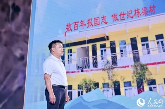 張玉滾分享用一根扁擔(dān)送孩子們走出大山的故事。人民網(wǎng)攝