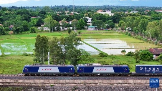 8月5日，由老撾籍火車司機(jī)獨(dú)立駕駛的滿載貨物的列車駛出萬象站，向中國昆明進(jìn)發(fā)（無人機(jī)照片）。新華社發(fā)（楊永全 攝）