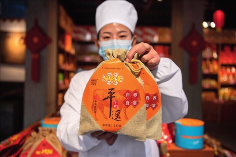 在位于山西省晉中市平遙縣的平遙古城南大街的一家平遙牛肉店內(nèi)，工作人員展示一款牛肉產(chǎn)品（資料照片）楊晨光攝 / 本刊