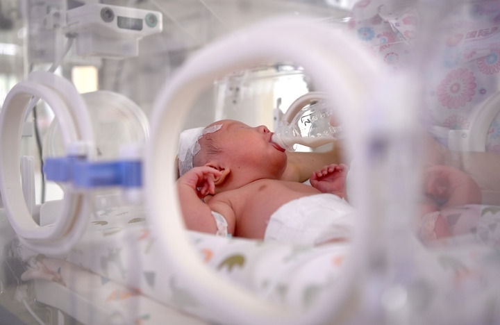 2024年6月1日，在西安國際醫(yī)學(xué)中心醫(yī)院新生兒科病房，護士為新生兒喂奶。 新華社記者 劉瀟 攝