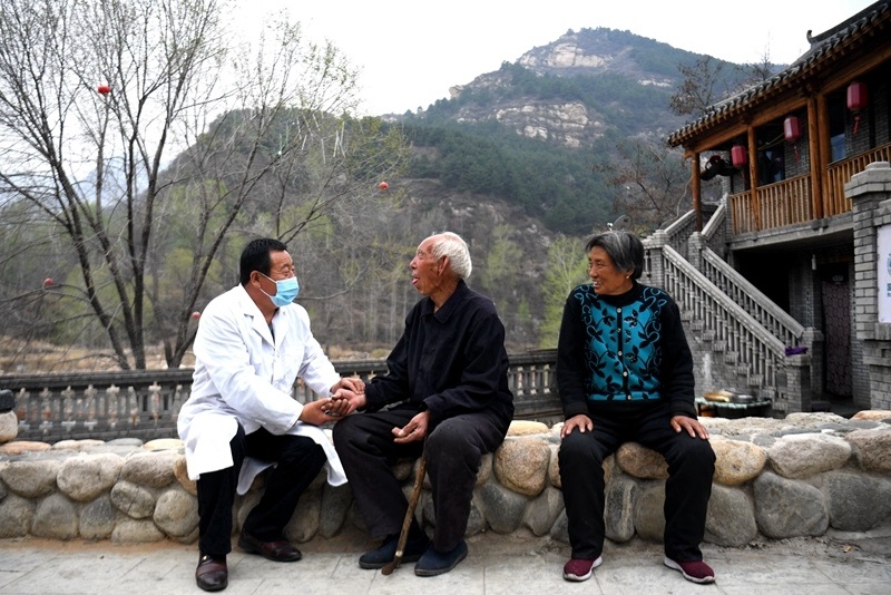 2020年4月15日，在河北阜平縣龍泉關(guān)鎮(zhèn)駱駝灣村，村醫(yī)霍建國為村民把脈。