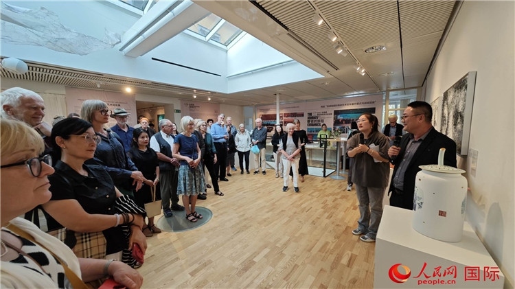 參展人、景德鎮(zhèn)陶瓷大學(xué)美術(shù)學(xué)院副院長邵長宗（右一）向來賓介紹參展作品。人民網(wǎng)記者 殷淼攝