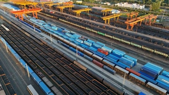 這是2024年8月14日在黑龍江綏芬河鐵路口岸集裝箱換裝場拍攝的集裝箱換裝作業(yè)現(xiàn)場（無人機照片）。今年前七個月，綏芬河鐵路口岸開行中歐班列573列，運量達55246標箱，同比分別增長23%和18%，班列數(shù)量持續(xù)保持高位運行。