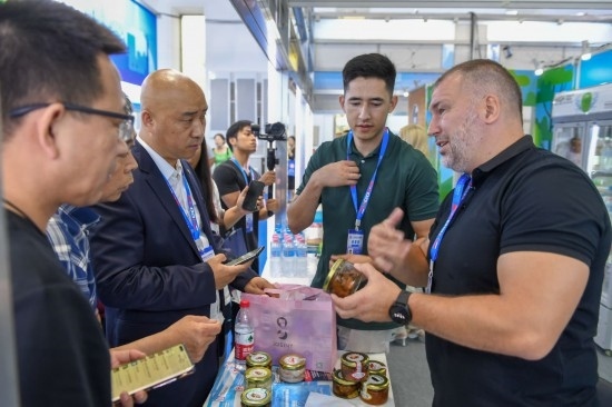 2023年8月23日，在第十四屆中國—東北亞博覽會東北亞商品館，俄羅斯參展商向參觀者介紹商品。