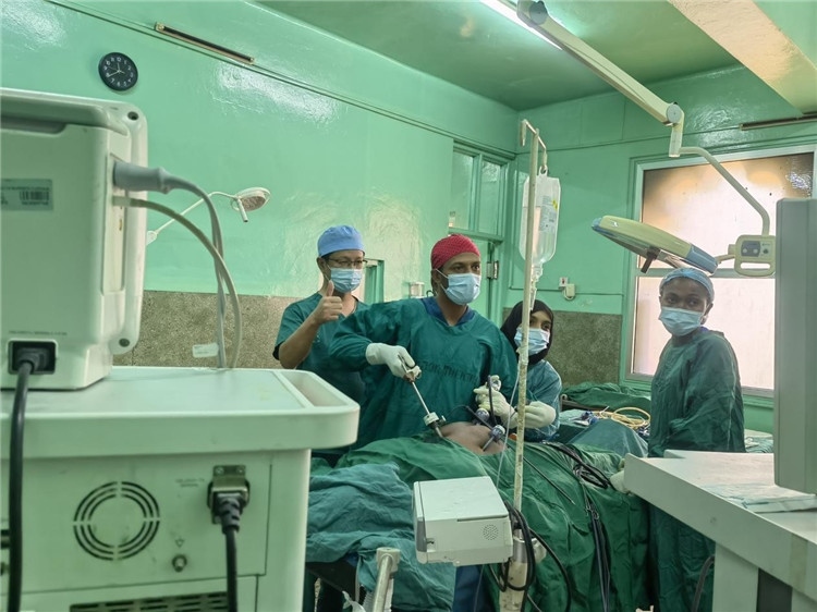 隊長蔣國慶（左一）關注當地醫(yī)生手術情況。中國援桑醫(yī)療隊供圖