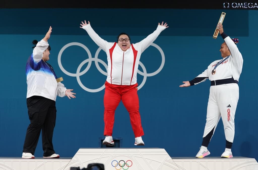 中國選手李雯雯（中）在巴黎奧運會舉重女子81公斤以上級頒獎儀式中登上領(lǐng)獎臺（2024年8月11日攝）。新華社記者 楊磊 攝