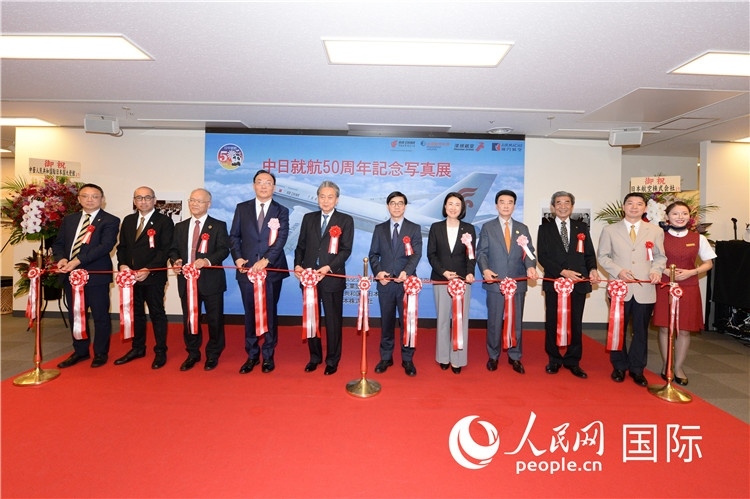 與會(huì)嘉賓共同為中日通航50周年紀(jì)念圖片展開(kāi)幕剪彩。馮學(xué)敏攝