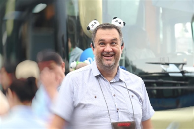 參訪(fǎng)熊貓谷前，塞爾維亞“一帶一路”研究所所長(zhǎng)博揚(yáng)·拉利奇戴上熊貓頭飾。（李佩藺 攝）