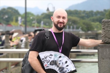 俄羅斯塔斯社執(zhí)行編輯葉夫根尼·扎多羅日內(nèi)在都江堰魚嘴拍照留念。（李佩藺 攝）