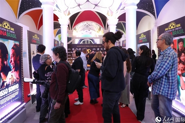 為期4天的第三屆中國(guó)－巴西電影展期間，來自中巴兩國(guó)的14部參展影片受到巴西電影愛好者和社會(huì)各界人士好評(píng)，圖為當(dāng)?shù)赜^眾在影展舉辦地巴西里約熱內(nèi)盧勞拉—阿爾維姆文化之家的迎賓廳欣賞參展電影海報(bào)。 人民網(wǎng)記者 陳一鳴攝