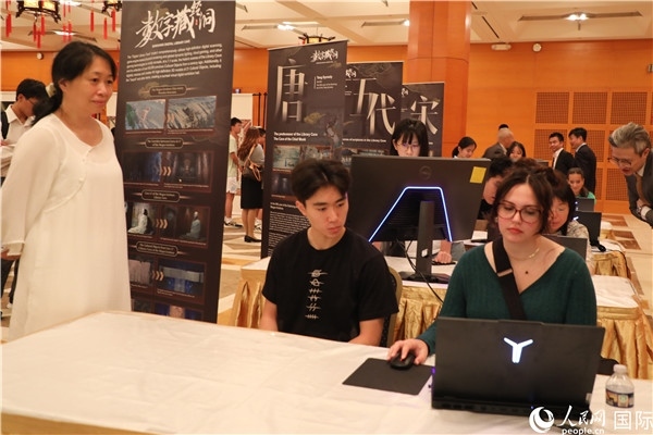 在活動(dòng)現(xiàn)場(chǎng)，當(dāng)?shù)孛癖婓w驗(yàn)“數(shù)字藏經(jīng)洞”云游戲，沉浸式體驗(yàn)敦煌文化。 人民網(wǎng)記者 李志偉攝