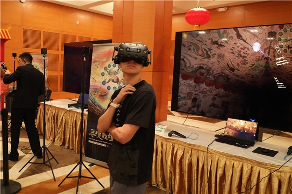 1、在本次活動(dòng)的展覽現(xiàn)場(chǎng)，敦煌研究院與騰訊展示了“數(shù)字藏經(jīng)洞”和“尋境敦煌”等創(chuàng)新互動(dòng)產(chǎn)品。圖為當(dāng)?shù)孛癖娡ㄟ^(guò)VR虛擬游覽洞窟。 人民網(wǎng)記者 李志偉攝