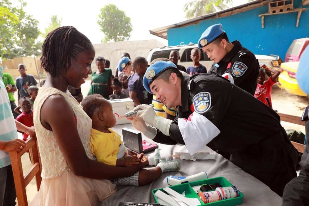 2017年12月28日，在利比里亞蒙羅維亞，中國(guó)維和警察防暴隊(duì)醫(yī)療人員為兒童做口腔檢查。