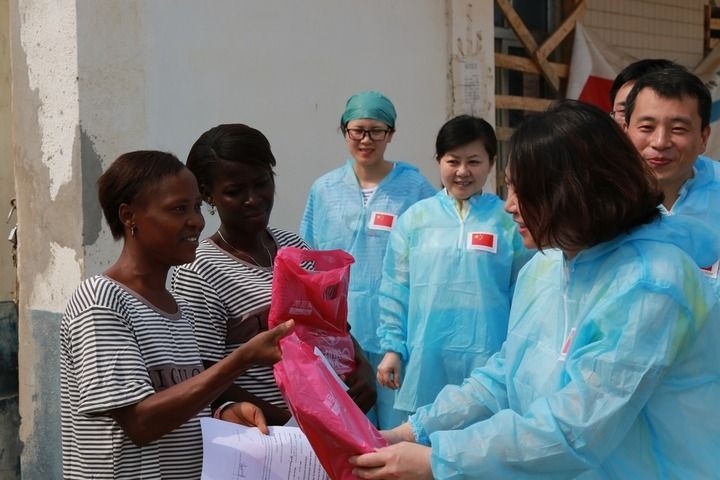 2015年4月4日，在位于塞拉利昂首都弗里敦市郊的中塞友好醫(yī)院埃博拉診療中心，中國第四批援塞醫(yī)療隊副隊長邵蔚（右前）向被治愈的埃博拉出血熱患者贈送禮物。新華社發(fā)（祖榮強 攝）