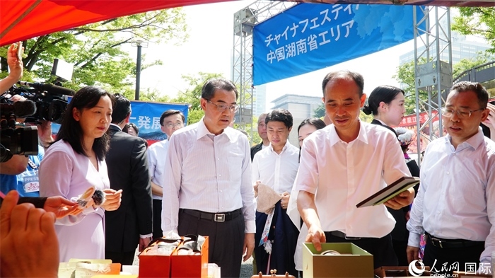 湖南展位工作人員向中國(guó)駐日本大使吳江浩介紹特色文創(chuàng)產(chǎn)品。人民網(wǎng) 蔣曉辰攝