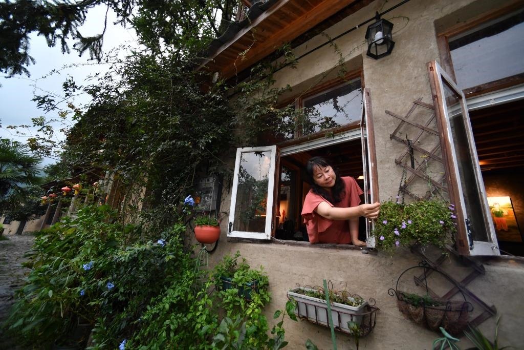 8月29日，在福建省屏南縣熙嶺鄉(xiāng)，龍?zhí)洞濉靶麓迕瘛泵泛暝诖蚶碜约航?jīng)營(yíng)的民宿外墻裝飾花盆。新華社記者姜克紅 攝