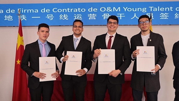 當?shù)貢r間9月13日，40名哥倫比亞青年與中企承建運營的波哥大地鐵一號線項目簽約，不久將前往中國進行為期15個月的專業(yè)地鐵知識培訓。圖為部分學員在簽約儀式上展示所簽的協(xié)議。 波哥大地鐵一號線項目供圖