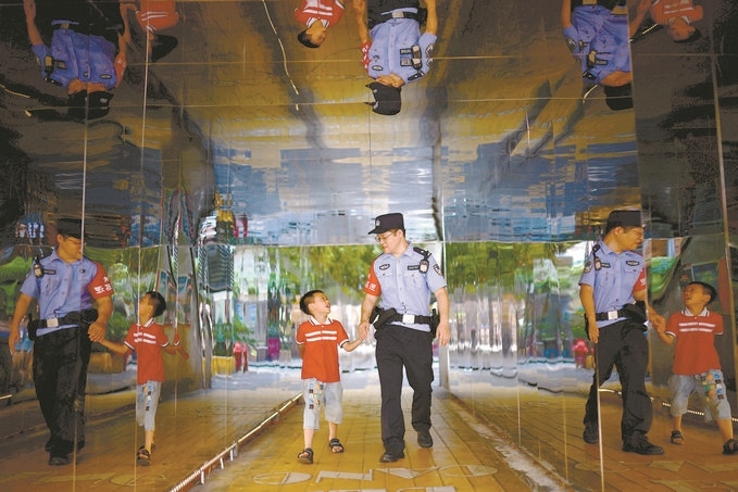 ?7月16日，重慶市公安局江北區(qū)分局一名民警在巡邏途中遇到一個(gè)獨(dú)自玩耍的小男孩，民警將其送回家。王洪平攝