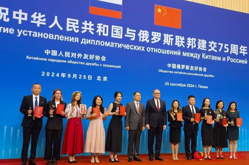 楊萬明會長和莫爾古洛夫大使為10位中俄青年友好微視頻創(chuàng)意大賽獲獎代表頒獎。人民網(wǎng)記者 李明琪攝