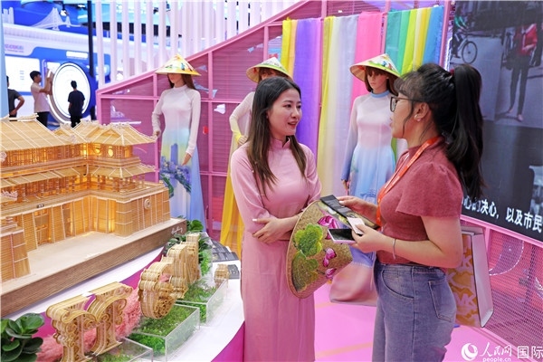 參觀者在東博會越南展區(qū)同工作人員咨詢交談。人民網(wǎng)記者 趙益普攝