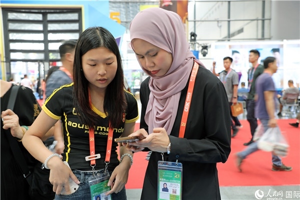 東博會現(xiàn)場，馬來西亞展商在同中方工作人員交談。人民網(wǎng)記者 趙益普攝