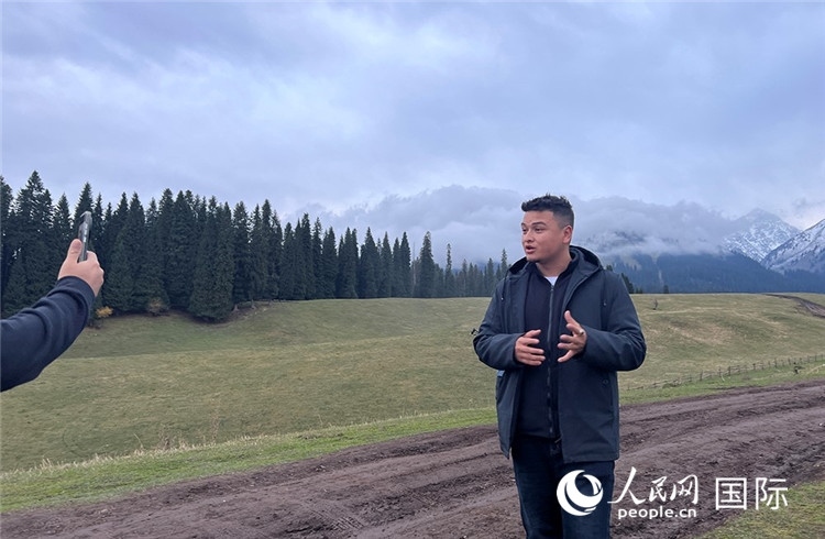 在庫爾德寧，吾買爾江被雪山美景震撼，即興錄制了短視頻作品。人民網(wǎng)記者曾書柔攝