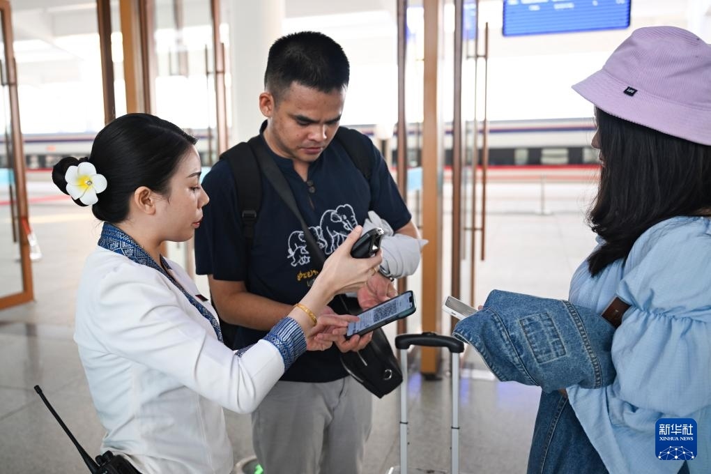10月12日，在老撾萬(wàn)象中老鐵路萬(wàn)象站，工作人員檢驗(yàn)乘客車票。新華社記者 程一恒 攝