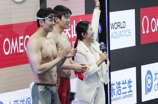  10月18日，汪順（左）和潘展樂在男子100米混合泳決賽后。新華社記者 方喆 攝