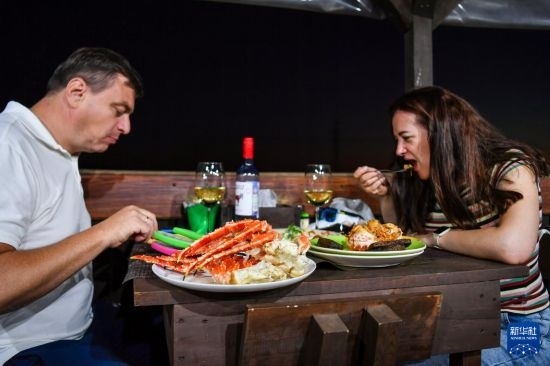 9月2日，食客們在俄羅斯符拉迪沃斯托克的一家餐館品嘗帝王蟹。新華社記者 曹陽 攝